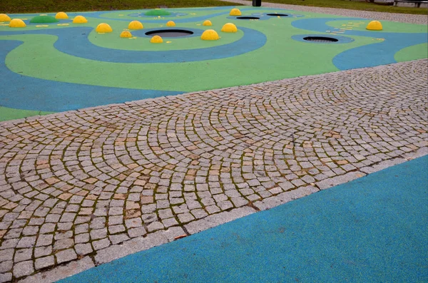 Blaue Gummioberfläche Eines Spielplatzes Mit Gelben Schaufeln Und Farbigen Flecken — Stockfoto