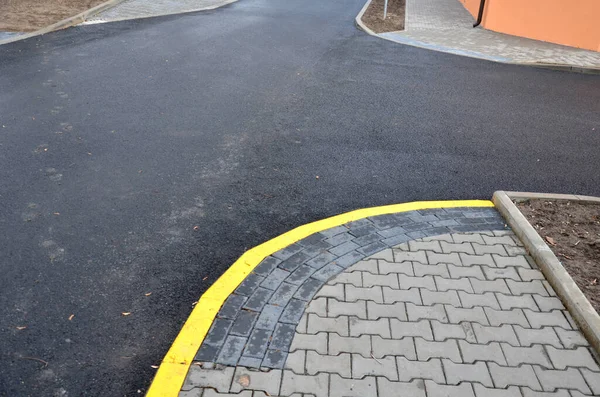 connecting the park path and sidewalk to the asphalt road using a strip of concrete blocks with protrusions for the blind. they know where the sidewalk ends with the mass of feet. drainage tiles soak up rain water