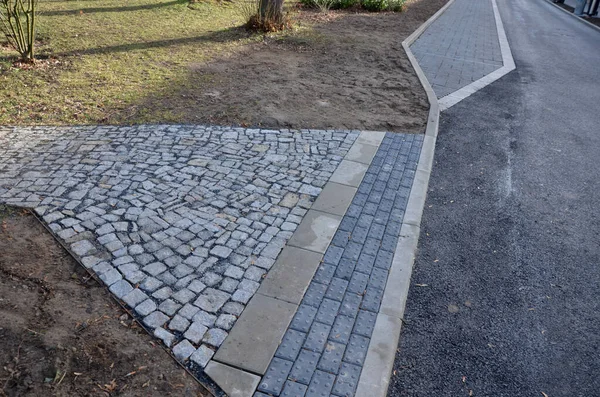 connecting the park path and sidewalk to the asphalt road using a strip of concrete blocks with protrusions for the blind. they know where the sidewalk ends with the mass of feet. drainage tiles soak up rain water