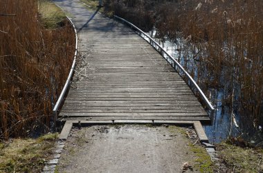Tahta kalaslardan, rıhtımdan, göl suyunun dibine kadar uzanan cambaz ayaklıklarının üzerindeki dar kıvrımlı patikalardan oluşan yüzen yürüyüş yolu. Korkulukları yok. Tekerlekli sandalyeler için daha çok korkuluklu kaldırım