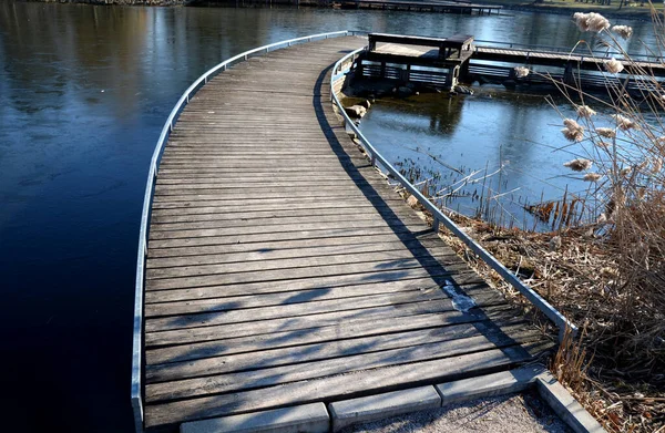 由木板 狭窄弯曲的小径构成的浮式人行道 高耸在高耸在湖面之上的台阶上 一直延伸到湖底 没有栏杆的 更多用于轮椅的低扶手的设计人行道 — 图库照片