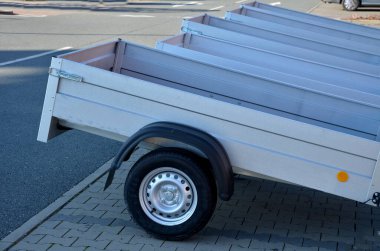 Kiralık dükkandaki otoparkta bir arabanın arkasında karavan. Sadece çekici aletin topuna koşum takımı. Homologlama ve teknik teftişler. metal yan paneller