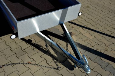 Kiralık dükkandaki otoparkta bir arabanın arkasında karavan. Sadece çekici aletin topuna koşum takımı. Homologlama ve teknik teftişler. metal yan paneller