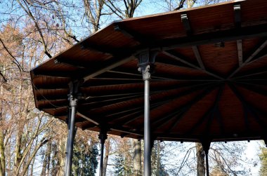Dekoratif kirişli çelik, ince çardak yapımı. Çatı düz bir piramit şeklinde ahşaptır. Çember dans pisti pergola ile kaplı, müzik çadırının terası.