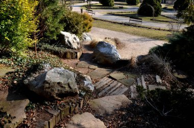 Japon bahçesindeki kaya bahçesi, taşlarla ahşap merdivenler, iyi düzenlenmiş bir Fransız bahçesi ve ilkbaharın başlarında ağaçlarla birleştirilmiş.