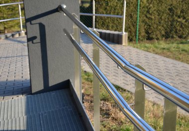 İki tırabzanla korkuluk. Galvanize çelik prizmalardan yapılmış. Alt korkuluk tekerlekli sandalyelere karşı bir koruma sağlar. Toplu konutlardaki hareketsizler için rampa.