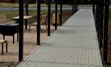 Otobüs durağının metal inşaatı, çardak pergola barınağı. Çatı ve duvarlar tırmanma tesisleri için bir halat ağıyla örülmüş. Paslanmaz çelik eşleşmelerle sabitlenmiş. siyah blok şekilli tünel,