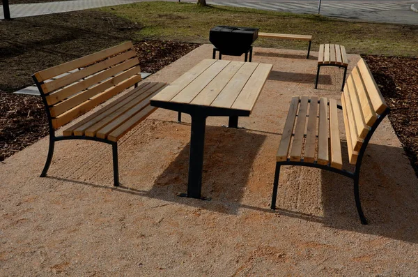 ペルゴラ ガーデンパビリオンは 金属グリルが装備されています 公共のバーベキュー場だ 木製のキャンプテーブル 公園のベージュの砂利の休憩所の周りの芝生 新しい — ストック写真