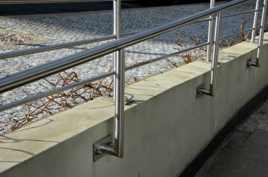 İki tırabzanla korkuluk. Galvanize çelik prizmalardan yapılmış. Alt korkuluk tekerlekli sandalyelere karşı bir koruma sağlar. Konutlardaki hareketsizler için rampa, paslanmaz çelik, merdiven, rampa.