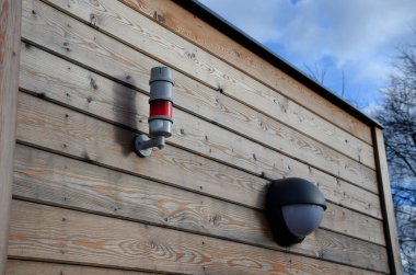 Evin ahşap duvarına bir çan sireni yerleştirildi. Endüstriyel bir fabrika ya da okulda yangın söndürücü kullanıldığı bildirildi. Tahta paneller ve duvar ışığı,.