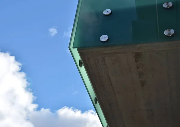 bus stop glazing. glass canopy attached at several points to a metal structure with stainless steel struts. tempered gluing glass pergola green blue color. design shed above the entrance