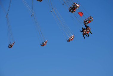 Düşük irtifada atlıkarıncaları olan eğlence endüstrisi dönme dolaptaki cesur ziyaretçileri döndürür. Zayıf mide baş dönmesine ve kusmaya neden olur. Zihin bulanıklığı ve coşku hali