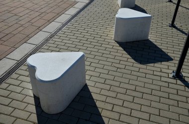 Yumuşak beton sandalye büyüklüğünde döşemeler. Yaya bölgesine girmek için kentsel tasarım bariyeri olarak uygun. Moka şekeri küpleri şeklinde. iskambil iskambil sembolü. Asfaltta beyaz kalpler