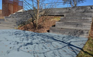 Parktaki gezinti alanında ahşap bir merdivenin altında metal kafes terası veya oditoryum bahçesi görevi görüyor. - Evet. Kare ağaç büyüme deliği. Paslanmaz çelik ızgaralar