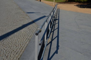 İki tırabzanla korkuluk. Galvanize çelik prizmalardan yapılmış. Alt korkuluk tekerlekli sandalyelere karşı bir koruma sağlar. Konutlardaki hareketsizler için rampa, paslanmaz çelik, merdiven, rampa.