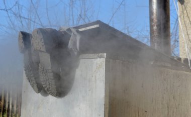 Cihazın kapağında sıcak su buharı ile tamir boruları. Sadece ayakkabılar ve ayaklar depodan dışarı bakar. Dumanlar rüzgarda yuvarlanıyor sis, toz. Paslanmaz çelik mutfak ekipmanları içerideki adamları, filmleri ve orduyu yıkıyor.