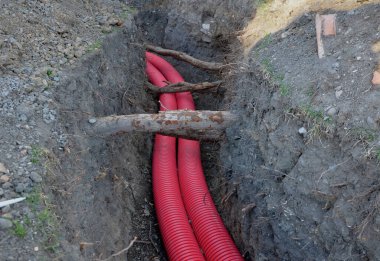 Yere yüksek voltaj kabloları döşüyordu. Çevre elektrik direklerine zarar vermez. Yerdeki kazı metresi güçlü kablolar ile kaplı kırmızı plastik kaplama. Saygılı bir şekilde Tree Ro 'dan geçer.