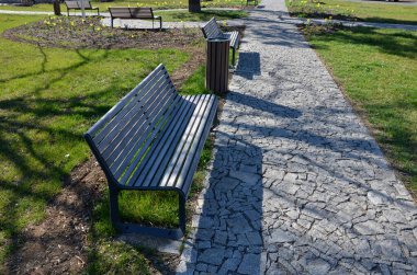 Baharın başlarında, siyah çalıların olduğu bir parktaki istinat duvarında banka uzanır. Yüksek çiçekli granit küplerden oluşan bir patikada Narcissus psödonarisis açar.