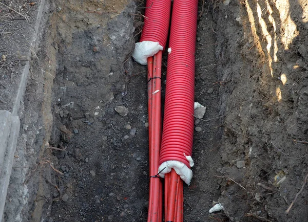 laying high voltage cables to the ground. the environment does not damage electric poles. Excavation meter deep in the ground red plastic coated with strong cable wires. respectfully undergoes tree ro