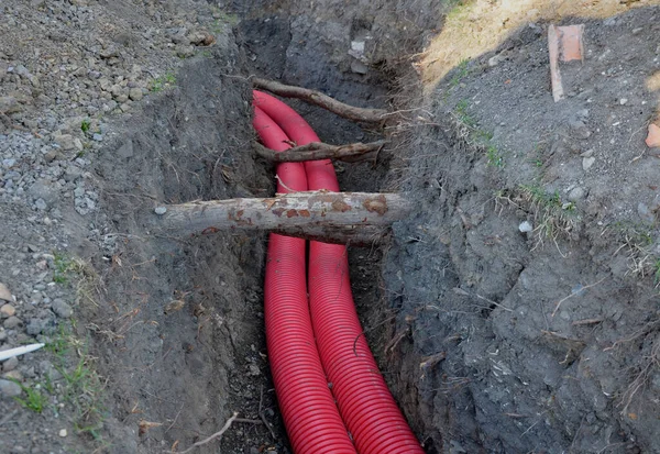 laying high voltage cables to the ground. the environment does not damage electric poles. Excavation meter deep in the ground red plastic coated with strong cable wires. respectfully undergoes tree ro