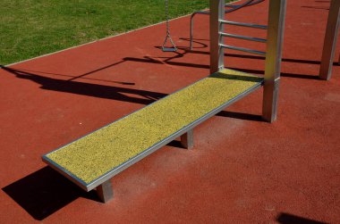 Paslanmaz çelik aletli fitness sahaları zincirli ve saplı işkence aletlerine benziyor. yumuşak kauçuk yüzey spor salonu. Adam makara tutuyor ve kaslarını güçlendiriyor.