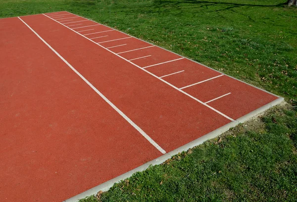 playground in the park, where he jumps on the playing area of rubber tiles with numbers. around is a lawn, the game is called jumping shot.