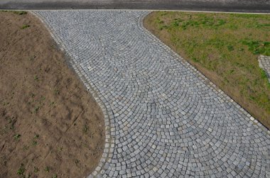 Ahşap prizmalar daire şeklinde istiflenmiş, daha iyi kurutulmuş. İnsansız hava aracından kemere giden yolda kaldırım taşları var. Parktaki içme suyu çeşmesi
