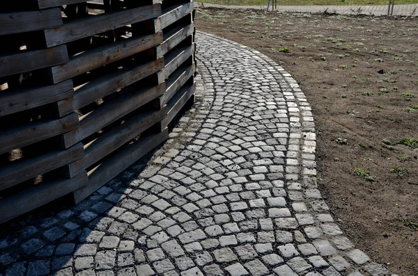 Ahşap prizmalar daire şeklinde istiflenmiş, daha iyi kurutulmuş. İnsansız hava aracından kemere giden yolda kaldırım taşları var. Parktaki içme suyu çeşmesi