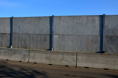 Ses geçirmez duvar, beton, gözenekli tırtıklı malzemeden yapılmış. Metal kirişlere gömülmüş gri bloklardan oluşan bir çit. Trafik gürültüsü bahçesi ve yerleşim alanı. Kudüs 'ün korunması, roket
