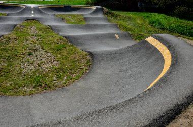 Otoparkta bisiklet yolu Pompalama (yukarı ve aşağı hareket) modüler pompa pisti boyunca bisiklet, scooter, kaykay ve dahili patenleri hareket ettirmek için pedal ve zıplama yerine kullanılır