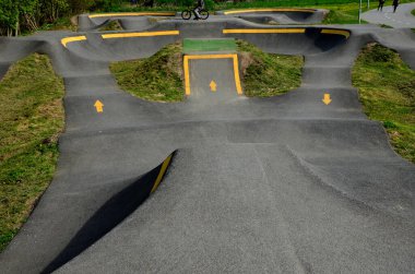 Otoparkta bisiklet yolu Pompalama (yukarı ve aşağı hareket) modüler pompa pisti boyunca bisiklet, scooter, kaykay ve dahili patenleri hareket ettirmek için pedal ve zıplama yerine kullanılır