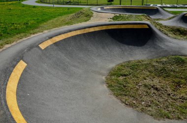 Otoparkta bisiklet yolu Pompalama (yukarı ve aşağı hareket) modüler pompa pisti boyunca bisiklet, scooter, kaykay ve dahili patenleri hareket ettirmek için pedal ve zıplama yerine kullanılır
