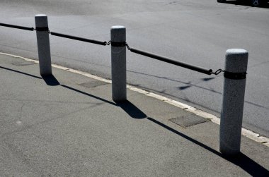 Kaldırımın kenarında zincir gibi asılı çubuklarla birbirine bağlanmış granit sütunlar var. Silindirik sütunlar yayaları araçlardan korur. taş ürünleri