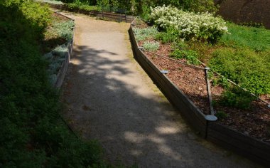 Büyüyen alanların çapraz bölünmüş bitkisel yatakları. Botanik türlerini eğitmek için profesyonel bir bahçıvanlık okulunun gösteri ve eğitim yatakları. Paslanmaz çelik eklemler. otururken