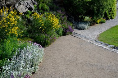 Asfaltlı bir dereye akan gölgeli bir bahçe. Ebedi bir yatağın içinden akıyor. Çimensiz bitkiler ıslak bir pınara dönüşür. Eğreltiotlarıyla kayalık çıkıntılar