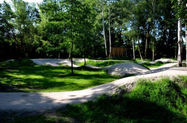 Ormanda bisiklet izleri, eğimli virajlar birbiri ardına mükemmel şekillerde kazılmış dağ bisikletleri çocuklar için bile, açıklık, güneş, gölgeler, yarış yenileri, çimenler...