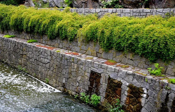 safety spillway of a lake dam, pond or other water area, reservoir. in case of clogging of the sluice, the water will drain out on the side through the stone wall and deceleration stones  sewerage
