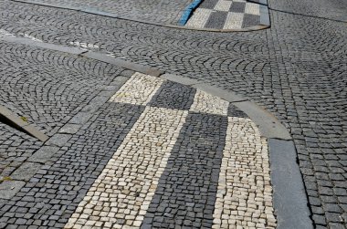 Küçük mermer küpler mozaiği. Kaldırımlar ve kareler taş halı ile şekillenmiş kareler, polka noktalar dalga desenleri. Taş halı pembe, beyaz koyu arkaplan. Ağacın altındaki uzayda bazalt kaba kaldırım