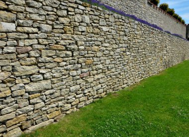 Yamaç parkında merdivenleri olan teraslar. Taş, hafif taşlı duvarlar içeriyor. Uzun ömürlü mavi lavanta ve pembe güller duvarın kenarında yetişir. Çimenler ve çakıl yolları, yol, patika, kale