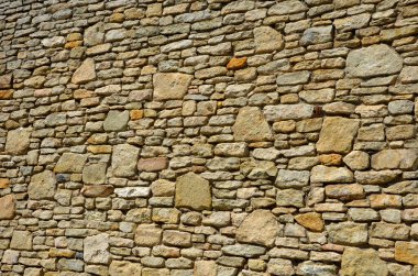 Granit tavan arası ve küçük eklemleri olan güzel katlanmış istinat duvarı. Kahverengi bej rengi düzensiz gneiss taşı üzerinde bir yamaç tutuyor. Etrafta talepsiz daimi varlıklar var.