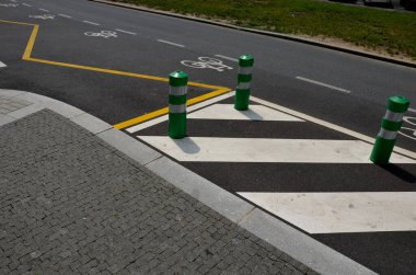 road signs drawn on the road side. zebra where he must not stop and park. asphalt with  support of green plastic posts. These posts are made of flexible rubber so they can beat,, paving. marble mosaic