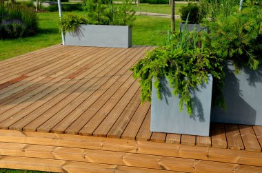 It is a heartwood that has a yellowish-brown to greenish appearance when fresh. separate wooden terrace on the lawn with fiberglass, plastic flower pots clipart