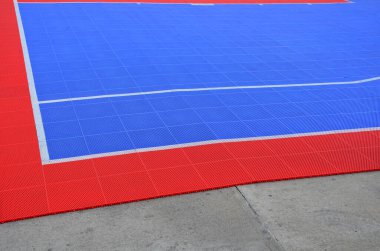 Otoparkta voleybol sahası kuruldu. Fayanslar birbirine bağlı ve taşınabilir olarak beton zeminde kırmızı-mavi plastik bir platform oluşturuyor. Yatak, plastik şebeke, kauçuk, yumuşak