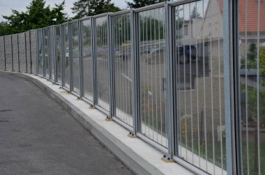 Caddede metal kirişlere gömülmüş bir köprü üzerindeki ses geçirmez mavi cam duvar. Trafik gürültüsü azaldı. Çelik kablolarla insanların üzerine düşmemek için güvenlik koruması