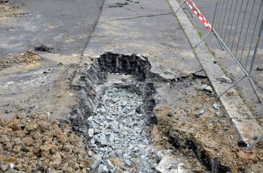 Makineli tüfeklerden, roketlerden, misket bombalarından ya da elektrik şebekelerinin sıradan tamiratlarından asfalt yollar fırlatıldı. Çekici yumruklarken, keskisinin ucuyla delikler açıyor ve bir kazı caddesini kırıyor.
