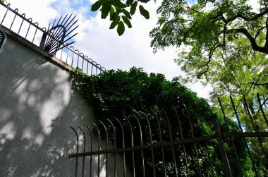 Dikenli demir parmaklıklardan çit örülmüş. Askeri üsler ve büyükelçilik içeriden kuşatılmaya karşı koruma sağlıyor. Çitin üzerindeki siyah parmaklıklar tehlikeli.