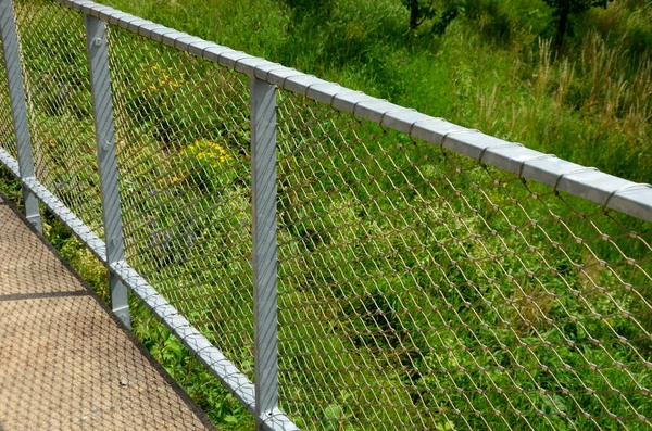 Terrace fencing, railings of metal pipes filled with steel cables cable mesh. fencing wire stainless steel fence. wooden floor, dance floor in the park, wire, galvanized railings, railing