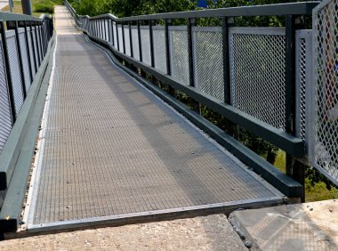 access ramp for disabled and wheelchair users. the elevation is spread over the long length of the pedestrian bridge. replaces the staircase
