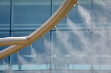 park air freshener with micro drip sprayer made of stainless steel in public park in hot summer will relieve runners who will refresh  here. children have fun here run through water, infection, yard