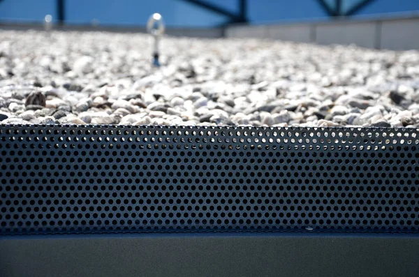 gravel mulch on the roof of a flat green roof. covers and protects layers of insulation and has a decorative effect. handle, staple, eyelet for tying the climbing rope and clips for safe work